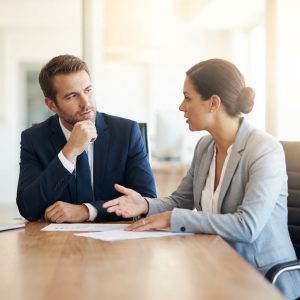 A high-net-worth individual meeting with an asset protection attorney to legally hide assets from creditors using an irrevocable trust strategy